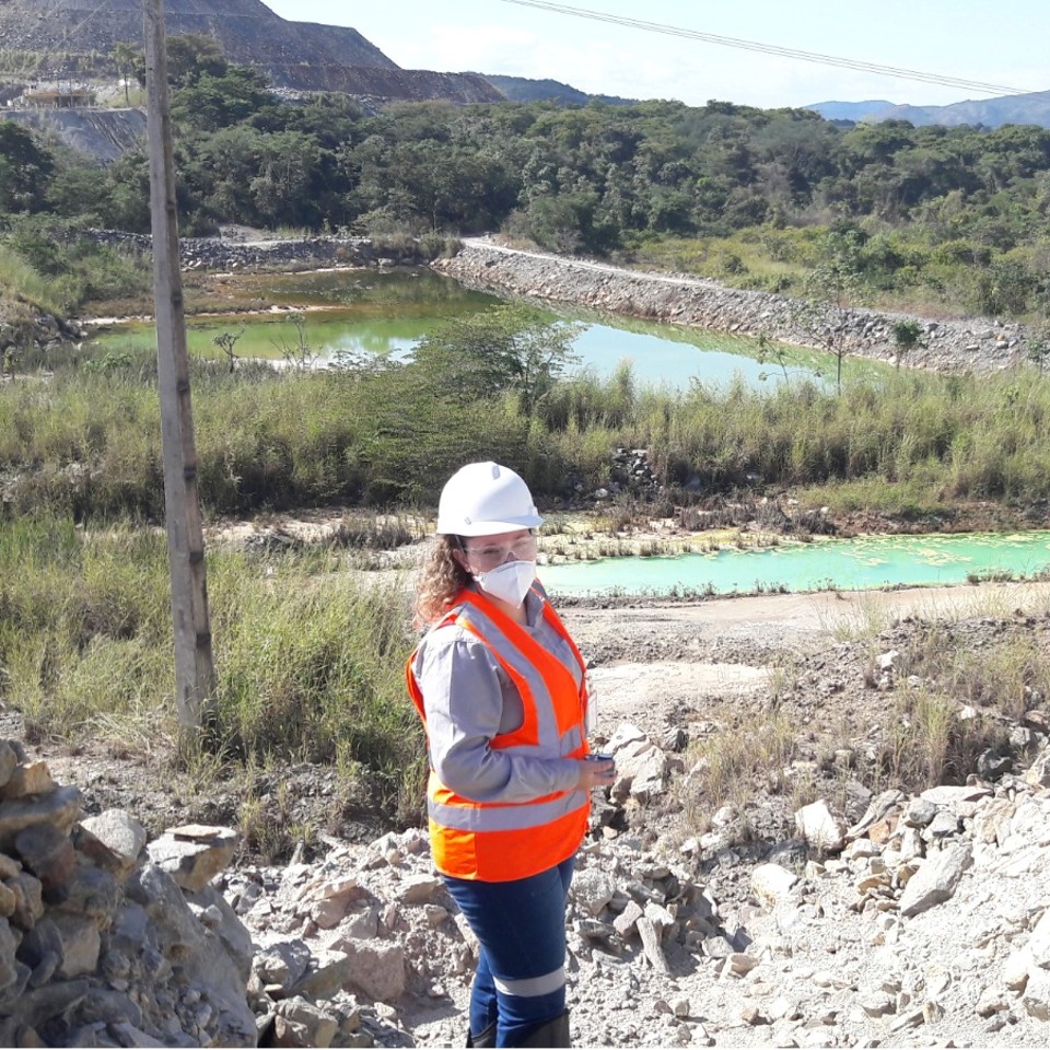 Engenheira da LiaMarinha em campo, com EPI, durante avaliação de corpo hídrico em área de mineração